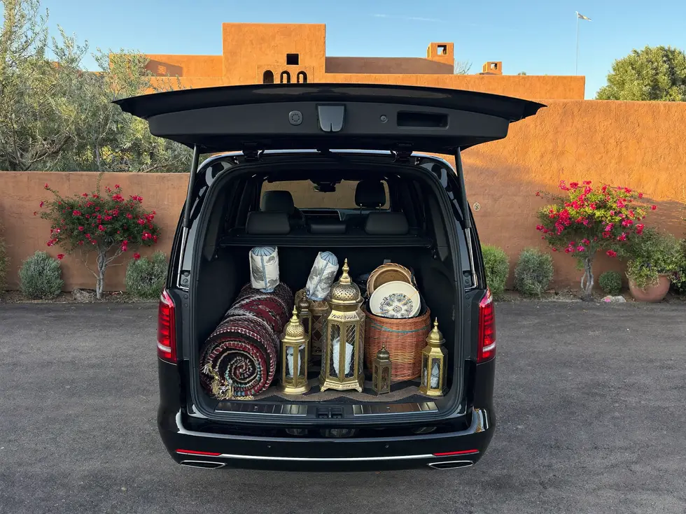 Coffre du van rempli de tapis, lanternes et paniers marocains