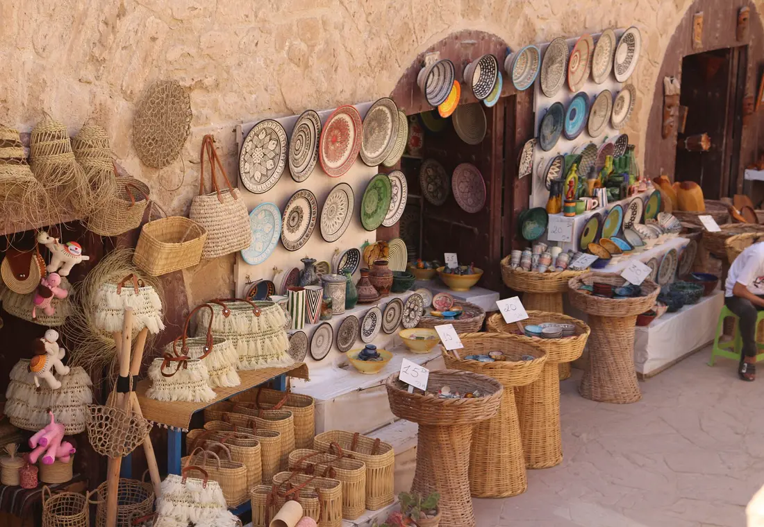 Étal d'artisanat marocain : plats peints, paniers et objets en bois