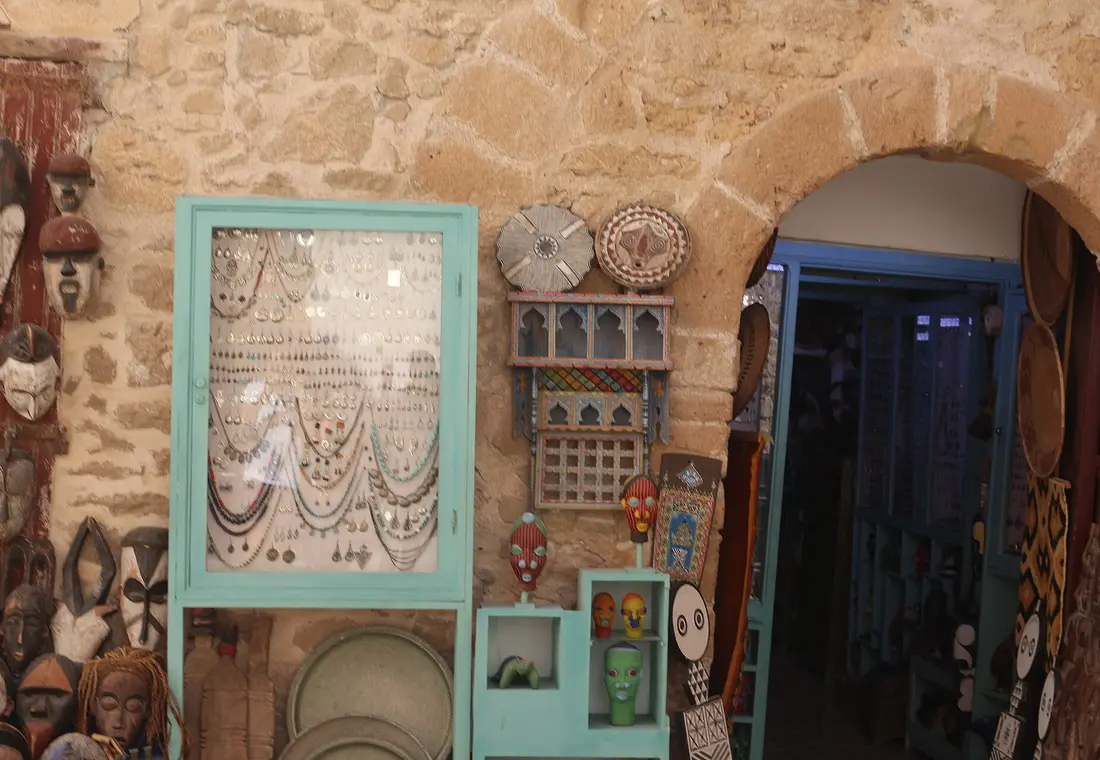 Bijoux, miroirs et objets décoratifs marocains sur un mur de pierre